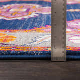 Close-up of the Kaitlyn Navy Area Rug showing the pile height with a ruler. Features navy, gray, pink, and mustard colors. Pile