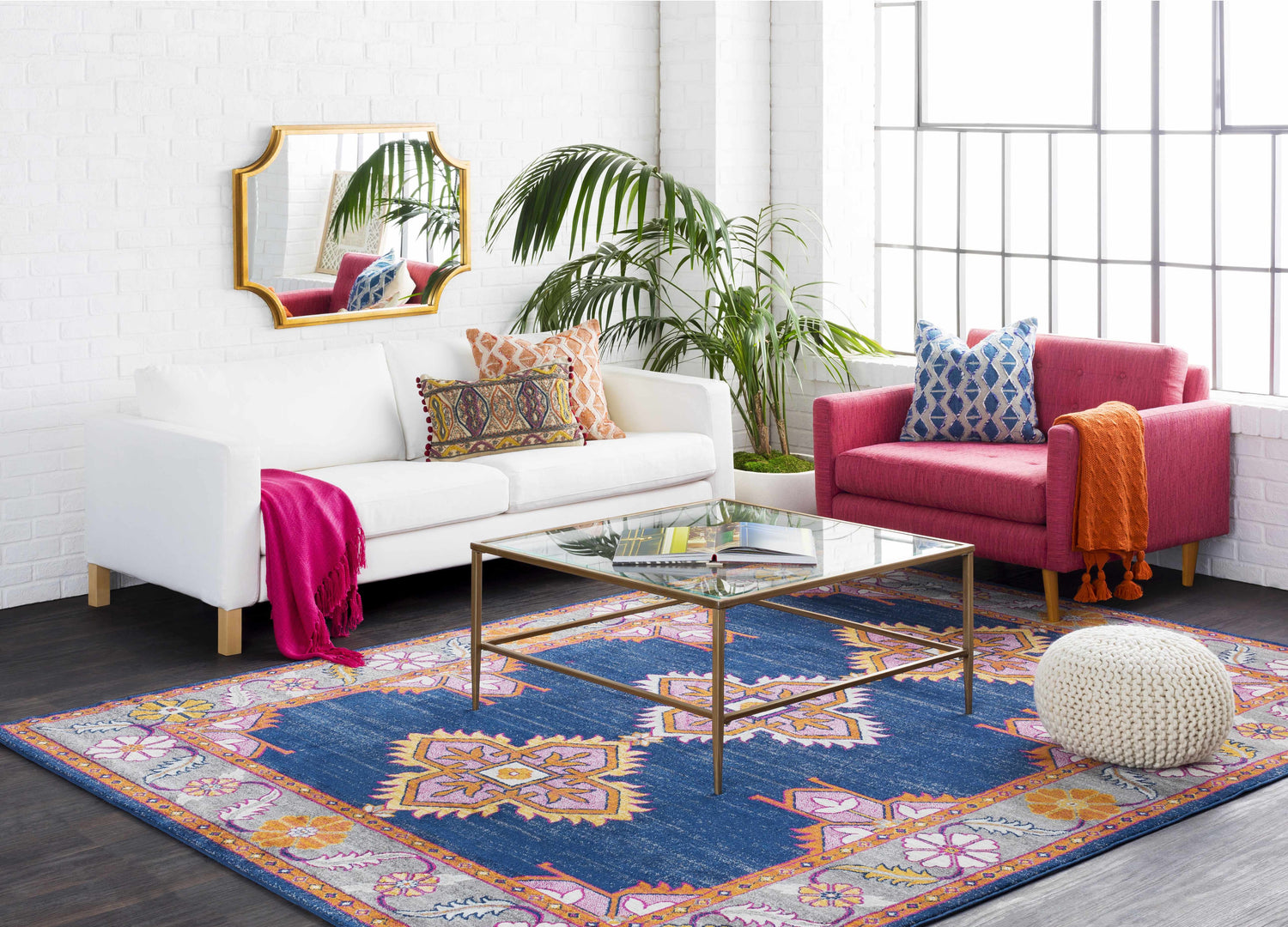 Living room scene with white sofa, pink chair, and Kaitlyn Navy Area Rug. Bohemian style. Roomscene-Rectangle