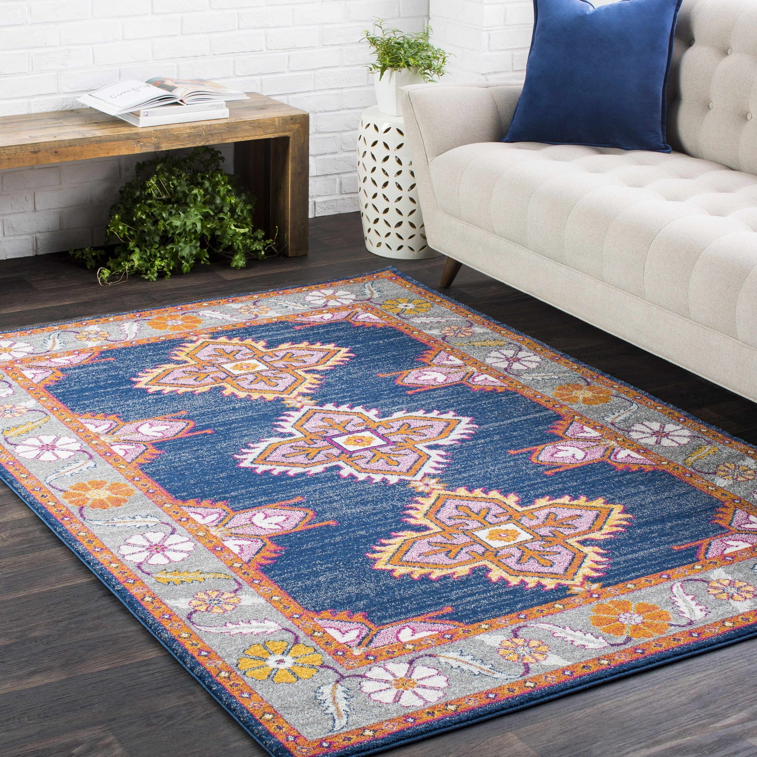 Living room scene with a navy Kaitlyn Area Rug, beige sofa, and rustic wood accents. Roomscene-Rectangle
