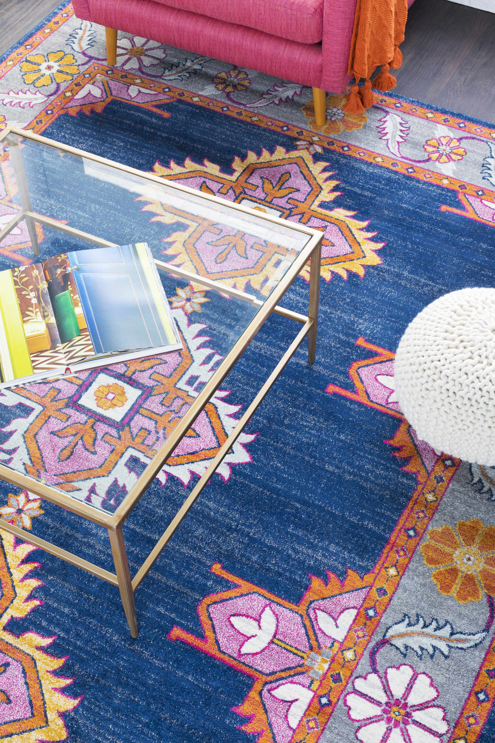 Living room scene with pink chair and Kaitlyn Navy Area Rug featuring a bohemian, floral pattern. Styleshot