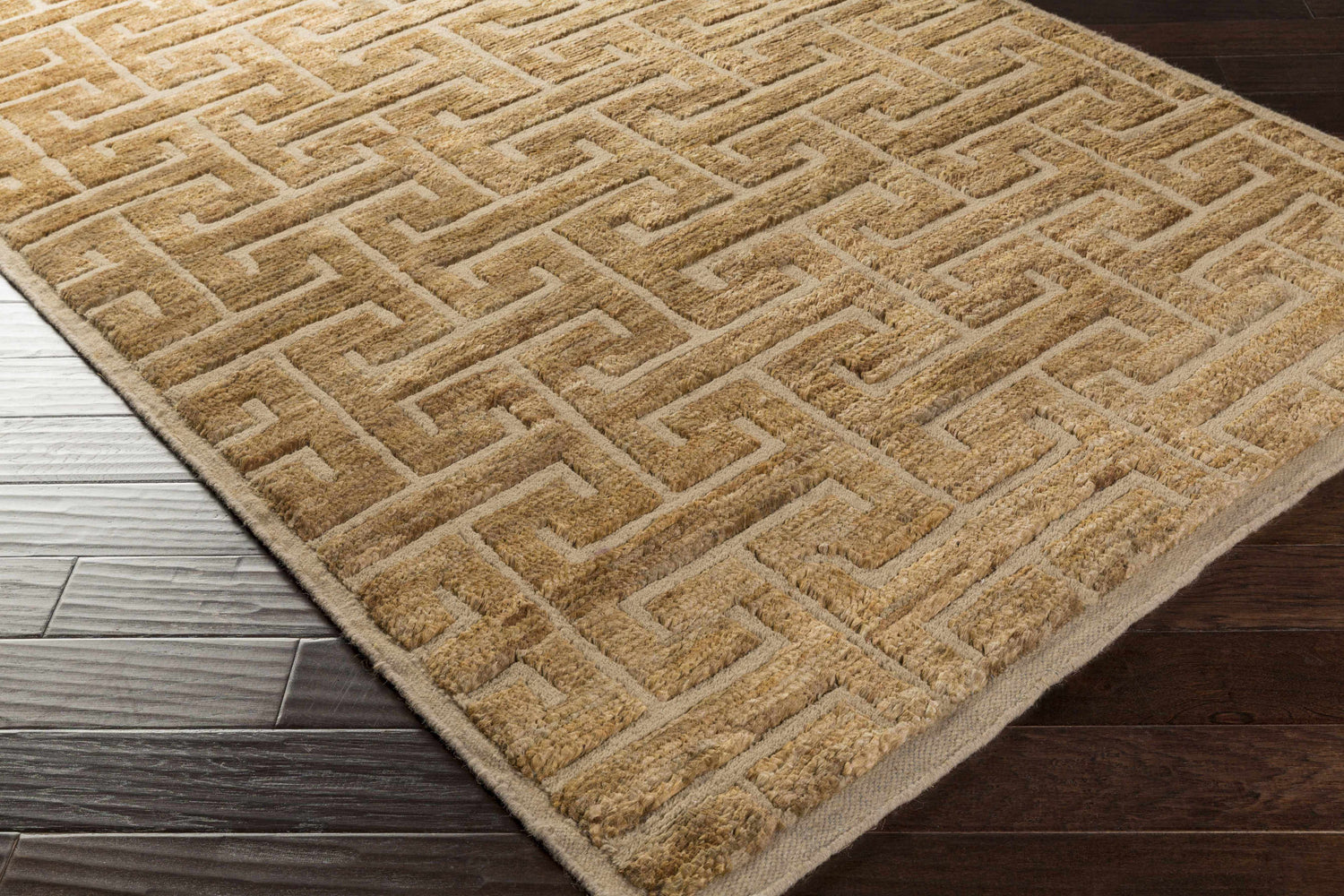 Close-up of the Kaiser Area Carpet. Brown jute and wool rug with a contemporary geometric pattern on dark wood floors. Corner