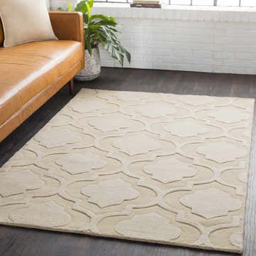 Living room scene with a tan leather sofa and the tan Kake Carpet featuring a contemporary quatrefoil design. Roomscene-Rectangle