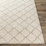 Close up of the Kanopolis Carpet, a hand woven rug with a cream and gray diamond pattern. Front