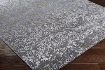 Close-up of the black Kechi Area Rug showing its traditional floral pattern and wool and viscose texture. Corner