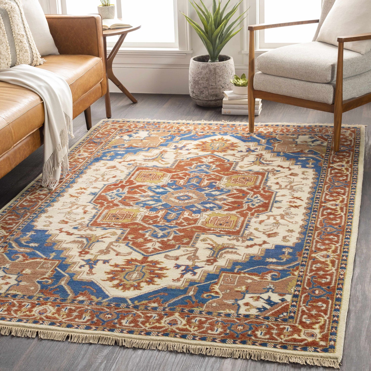 Styled room featuring a Kekaha Clearance Rug in blue, burnt orange, and tan with a traditional pattern and fringe detail. Roomscene-Rectangle