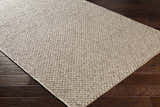 Close-up of the hand woven Keldron Clearance Rug. Charcoal and cream fibers with a textured, contemporary design. Corner