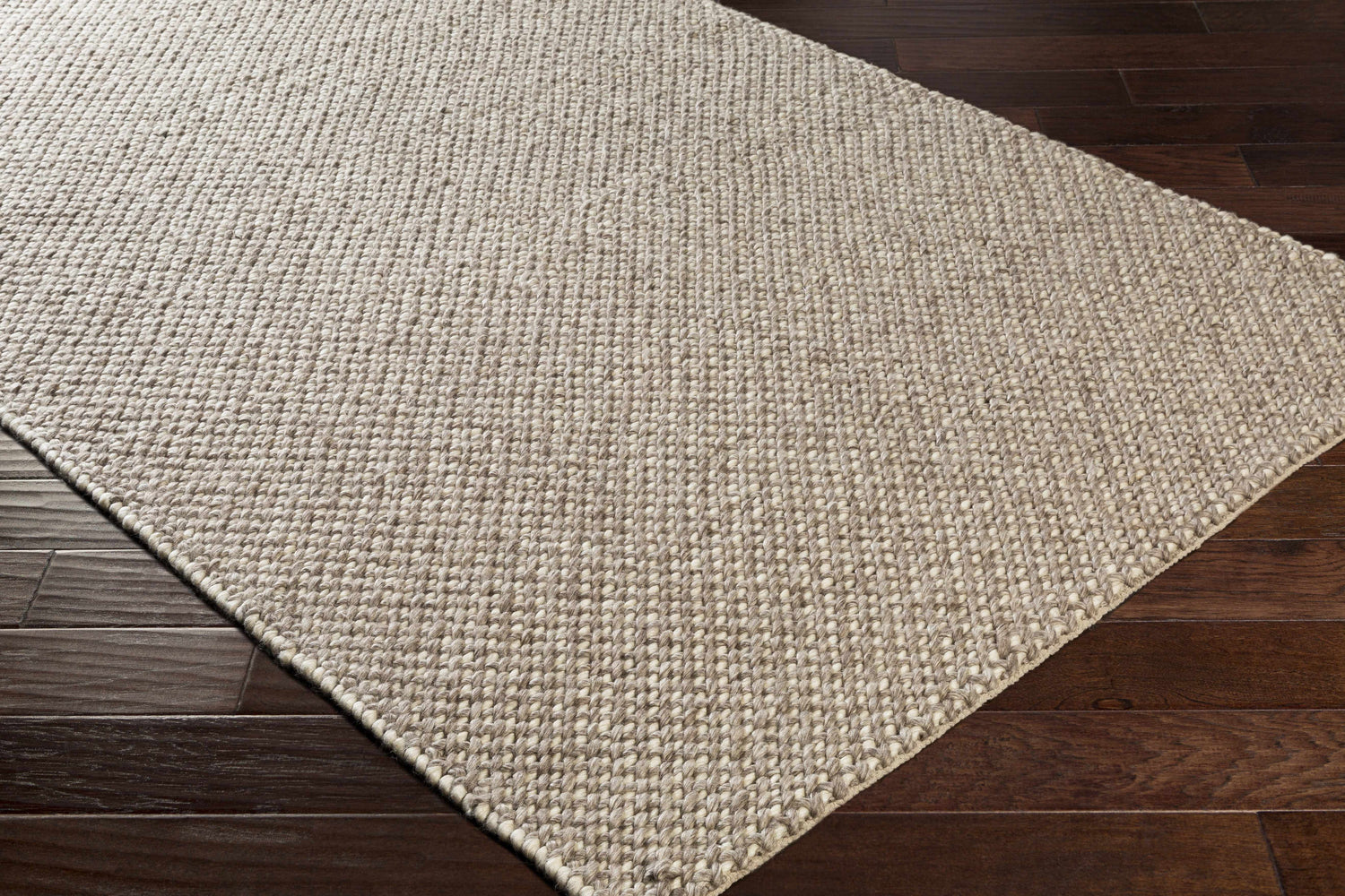 Close-up of the hand woven Keldron Clearance Rug. Charcoal and cream fibers with a textured, contemporary design. Corner