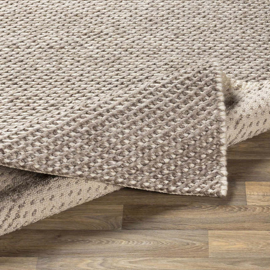Close-up of the hand woven Keldron Clearance Rug. Charcoal and cream wool and viscose blend with a textured, contemporary design. Fold