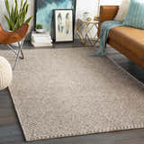 Living room scene with a charcoal and cream Keldron Clearance Rug, leather couch, and butterfly chair. Roomscene-Rectangle