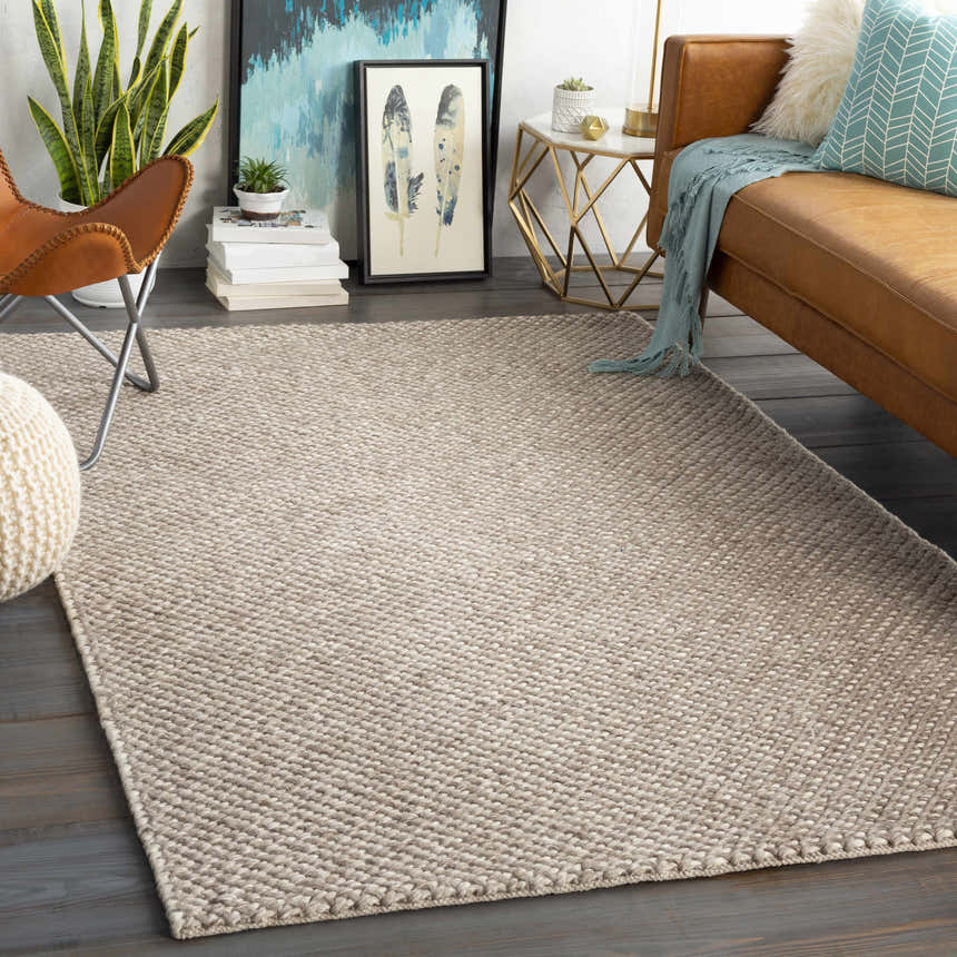 Living room scene with a charcoal and cream Keldron Clearance Rug, leather couch, and butterfly chair. Roomscene-Rectangle