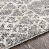 Close-up of the Kessingland Area Rug showing its beige, charcoal, and gray bohemian pattern and soft, textured pile. Texture