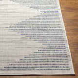 Close-up of the Khandallah Area Rug. Cream rug with dark gray and navy geometric stripe pattern. Machine woven texture. Front