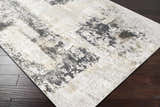 Close up of the Kiana Area Rug, a contemporary rug with a gray, white, and gold abstract pattern. Corner