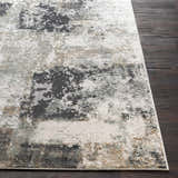 Close-up of the contemporary Kiana Area Rug, featuring a distressed abstract pattern in gray, white, and tan on dark wood floor. Front