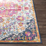 Close-up of the Kialla Magenta & Burnt Orange Area Rug showing the floral pattern, and colors: magenta, orange, and navy. Front