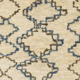 Close-up of Kinards Jute Carpet. Beige rug with dark blue and ink blue geometric diamond pattern. Hand-knotted texture. Swatch