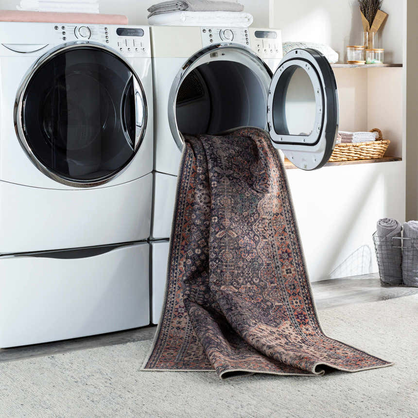 Beige Kittrell Vintage Flat Pile Washable Rug being pulled from a laundry dryer in a bright laundry room. Washing-Machine