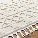 Close up of the ivory Kalkan High/Low Pile Rug with Tassels. Geometric pattern and tassel fringe detail. Texture