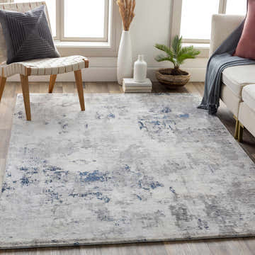 Living room scene with a blue and gray Killara Faux Silk Rug, white sofa, and modern chair. Roomscene-Rectangle