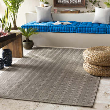 Relaxed sunroom with blue cushions, woven ottomans, and Kempston Gray Hand Woven Rug. Roomscene-Rectangle