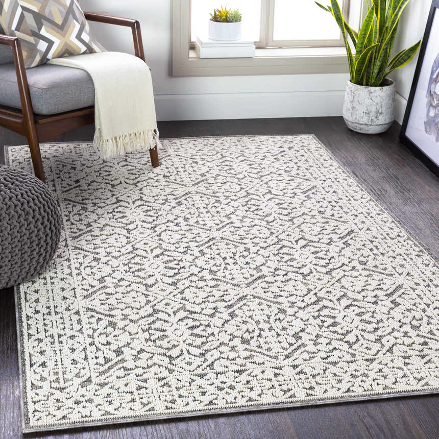 Living room scene with a gray chair, ottoman, and Kinglake Area Rug in black, gray, and white. Roomscene-Rectangle