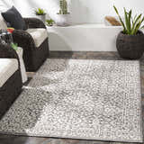 Outdoor patio scene with wicker chairs and a white and gray Kinglake Area Rug. Roomscene-Rectangle