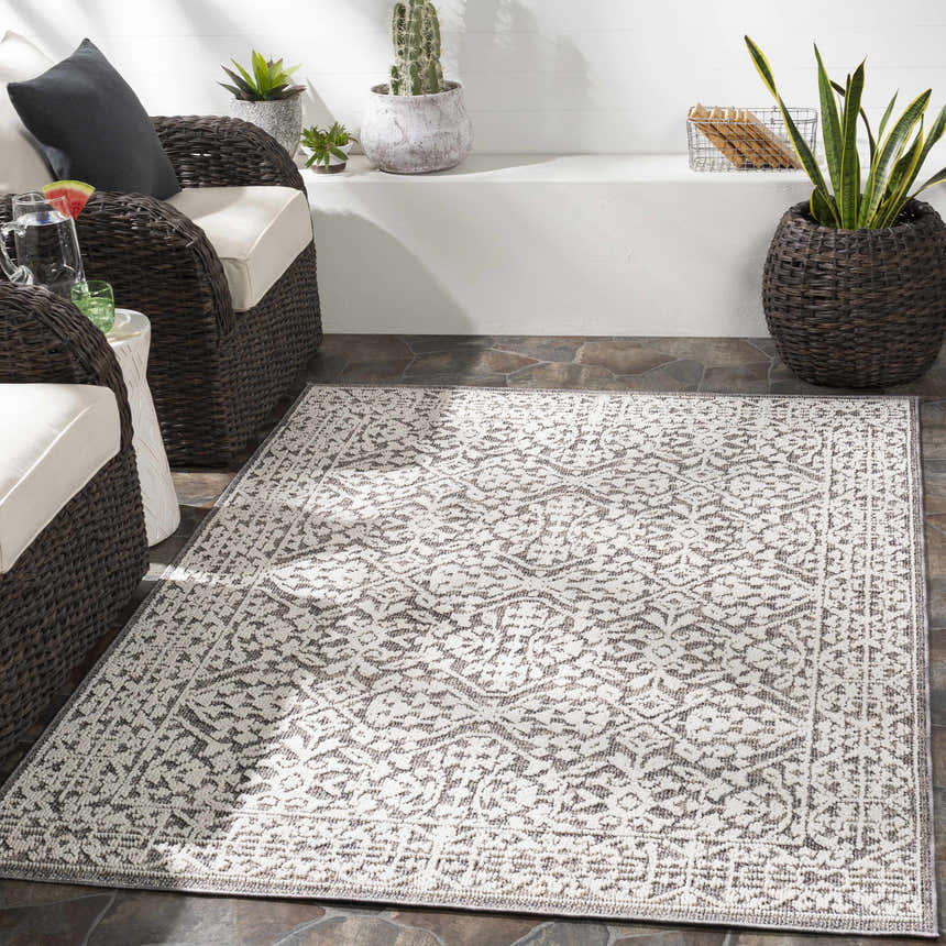 Outdoor patio scene with wicker chairs and a white and gray Kinglake Area Rug. Roomscene-Rectangle