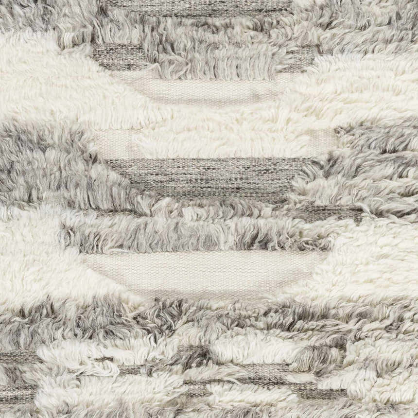 Close-up of the Kingsthorpe Area Rug showing cream, taupe, and dark brown shag wool in a horizontal striped pattern. Swatch