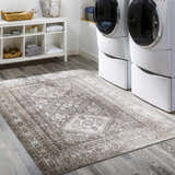Laundry room with white washer/dryer and Kingscourt Washable Area Rug in cream, brown, and gray. Roomscene-Rectangle
