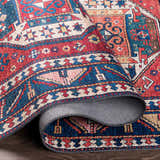 Close-up of the rolled-up Kodiak Red&Blue Oriental Area Rug showing its traditional pattern and colors: red, blue, and lambswool. Fold