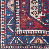 Close up of the Kodiak Red&Blue Oriental Area Rug. Features traditional geometric patterns in red, blue, and cream. Swatch