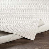 Close-up of the Kirkburton Beige Outdoor Rug showing its textured, geometric pattern and durable machine-woven construction. Fold