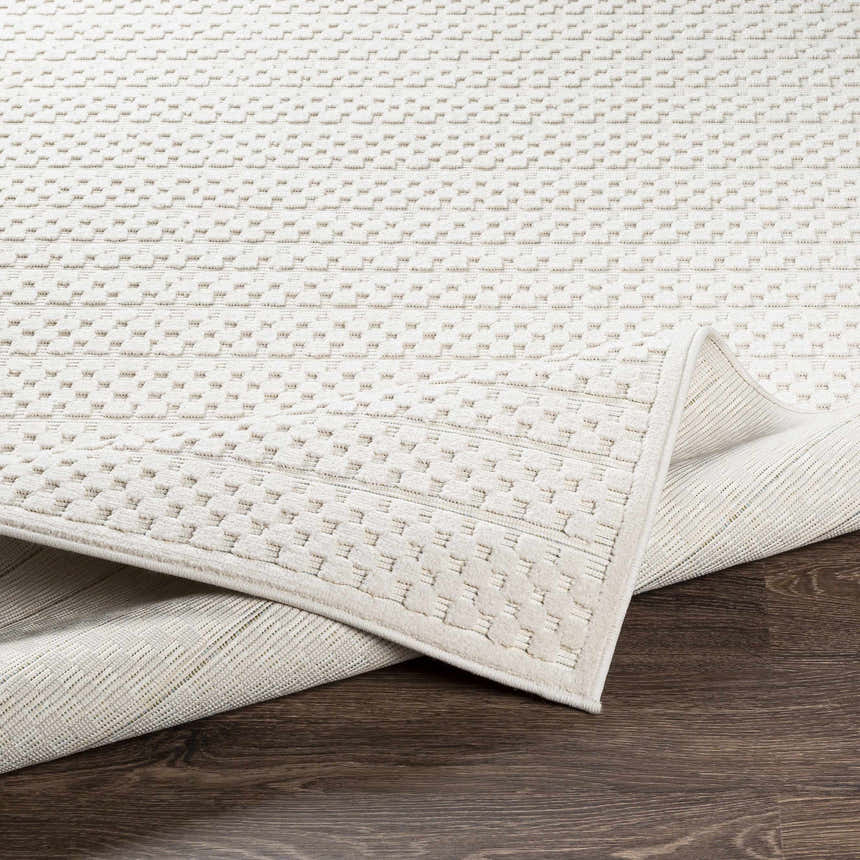 Close-up of the Kirkburton Beige Outdoor Rug showing its textured, geometric pattern and durable machine-woven construction. Fold