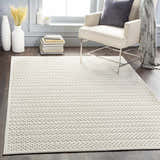 Living room scene with a Kirkburton Beige Outdoor Rug, armchair, and modern decor. Roomscene-Rectangle