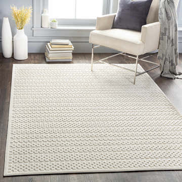 Living room scene with a Kirkburton Beige Outdoor Rug, armchair, and modern decor. Roomscene-Rectangle