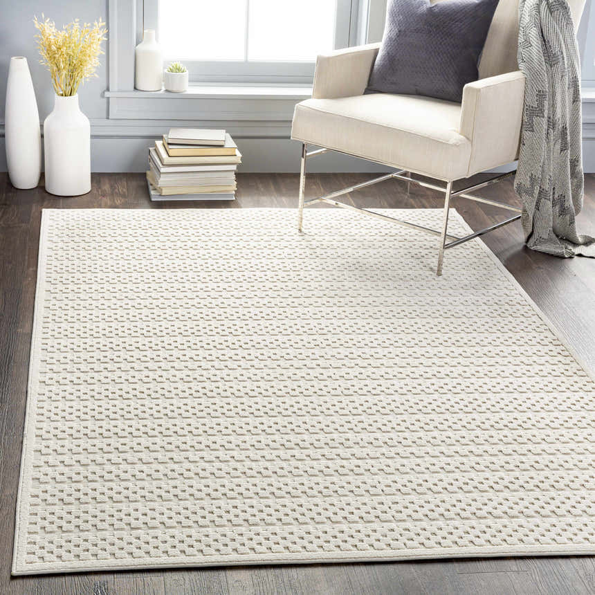 Living room scene with a Kirkburton Beige Outdoor Rug, armchair, and modern decor. Roomscene-Rectangle