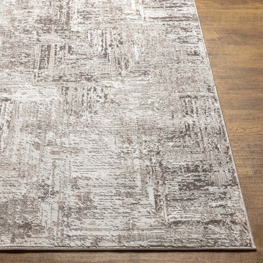 Close up of the Kutloanong Area Rug showing its abstract charcoal, gray, and ivory pattern. Front