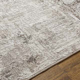 Close-up of the Kutloanong Area Rug showing a contemporary charcoal and ivory pattern and soft, textured polyester material. Texture