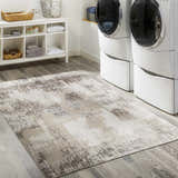 Laundry room with white washer/dryer and Kuyucak Washable Area Rug in brown, cream, and beige on gray wood-look tile. Roomscene-Rectangle