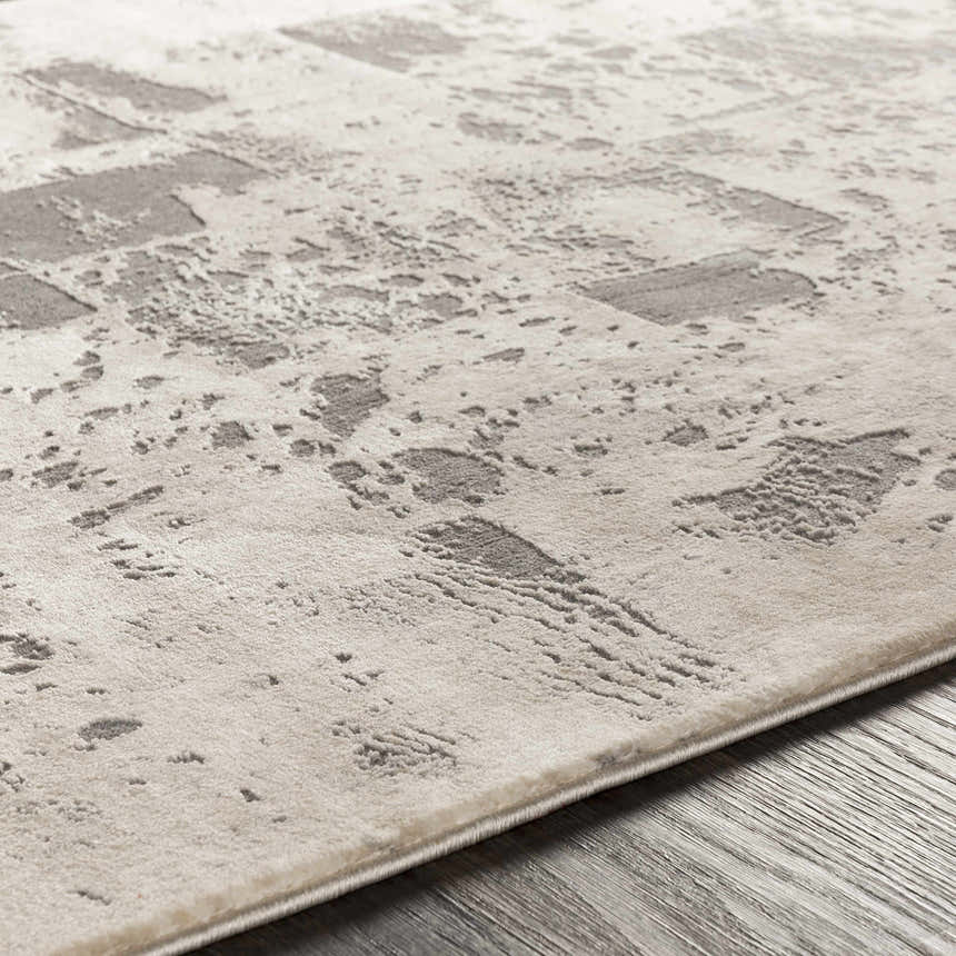 Close-up of the Lares Area Rug showing its light beige base and charcoal, mid-century modern pattern. Texture