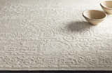 Close-up of the hand-knotted Larimer Area Rug. Cream wool rug with a raised, vintage-inspired geometric pattern. Styleshot