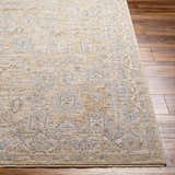 Close-up of the Coby Cream Avant Garde Rug showing its traditional pattern, brown, teal, and gray colors, and luxe texture. Front