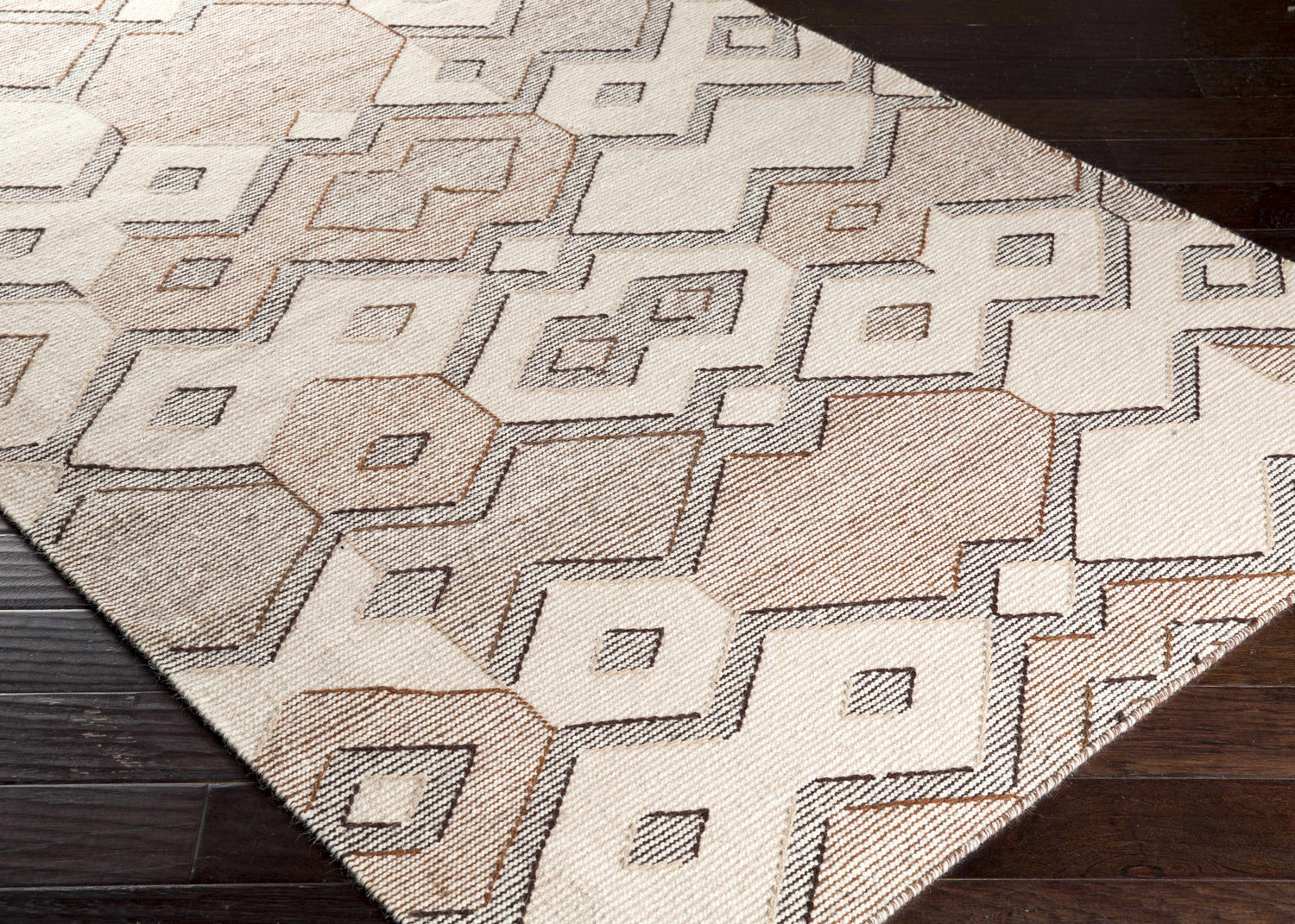 Close-up of the Latonia Area Carpet. Hand-woven wool rug with a contemporary geometric pattern in ivory, tan, and dark brown. Corner