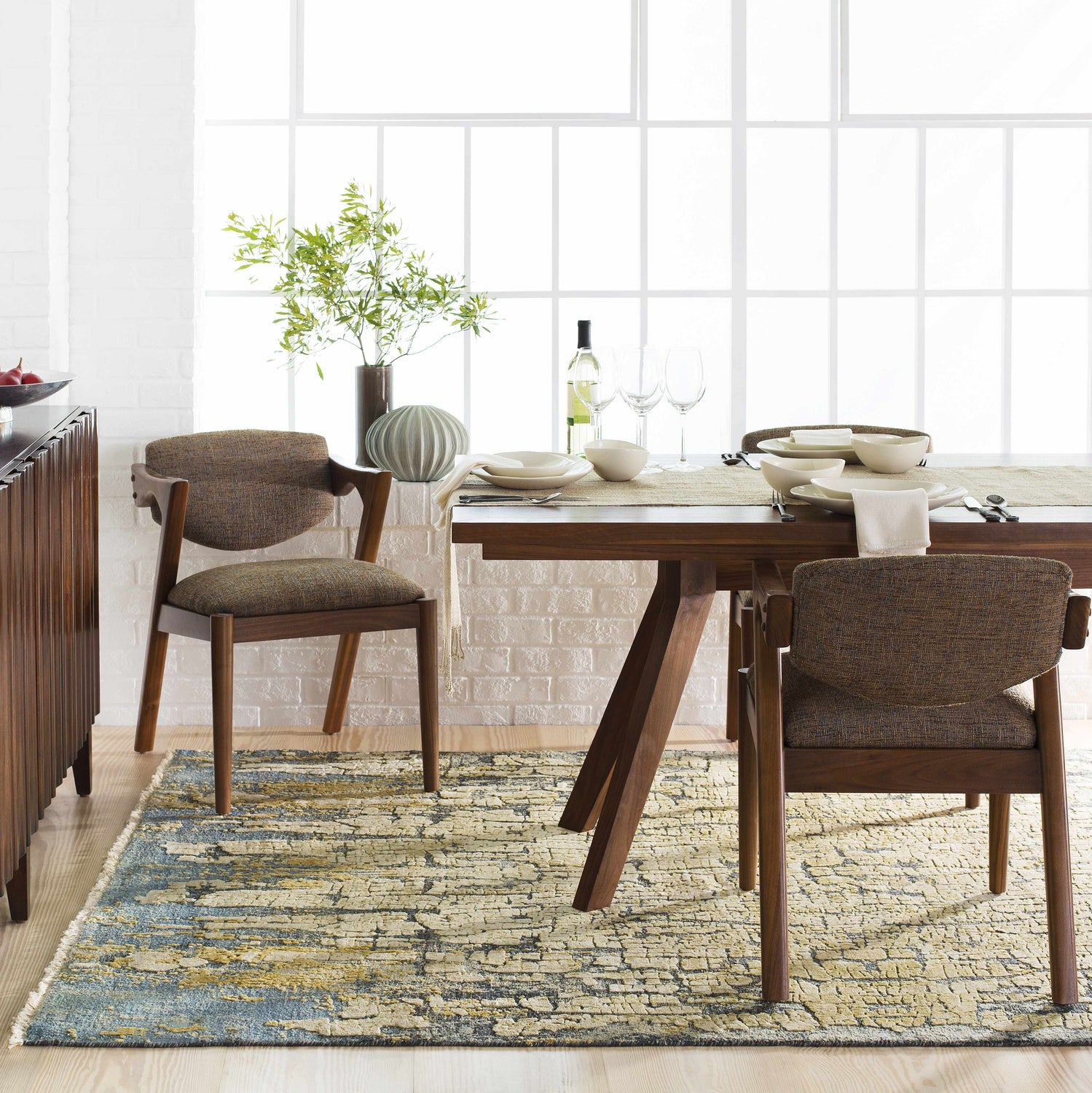 Dining room scene with the blue and olive Latour Carpet under a wooden table and chairs. Roomscene-Rectangle