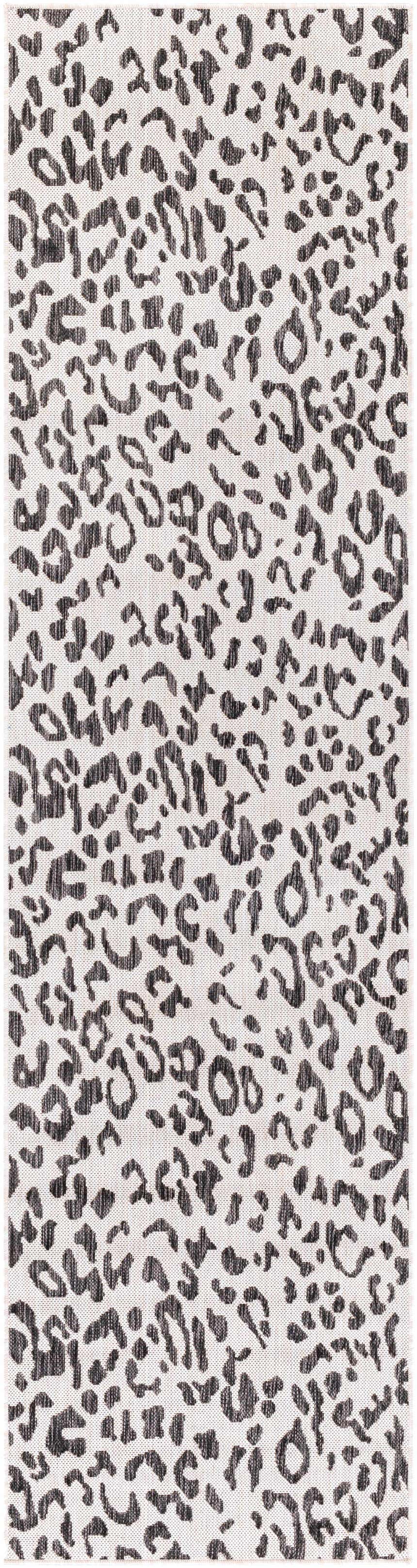 Close-up of the Alderbury White Leopard Print Rug. Features a black animal print pattern on an off-white polypropylene base. Design-Runner-2710