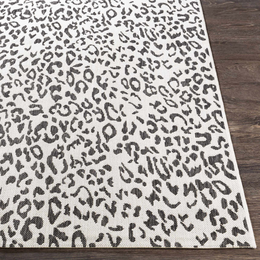 Close-up of Alderbury White Leopard Print Rug showing black animal spots on off-white woven polypropylene. Front