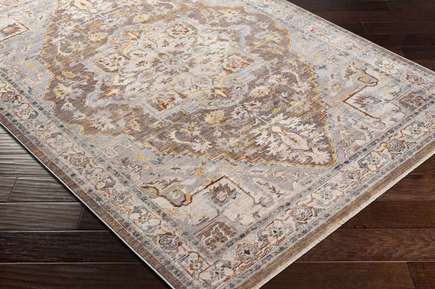 Close-up of the LeChee Area Rug. Traditional rug design in brick red, burnt orange, cream, and brown on a dark wood floor. Corner