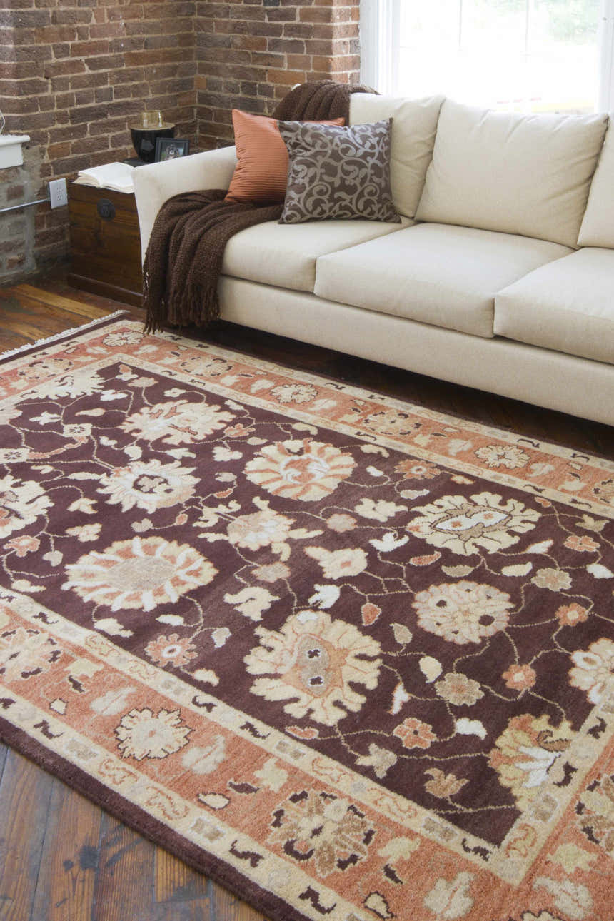Living room scene with the beige Lenapah Area Rug, a cream sofa, and exposed brick wall. Farmhouse style. Roomscene-Rectangle