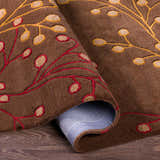 Close-up of the Brown Elsu Area Rug, a hand-tufted wool rug with a floral design in brown, burgundy, and gold. Fold