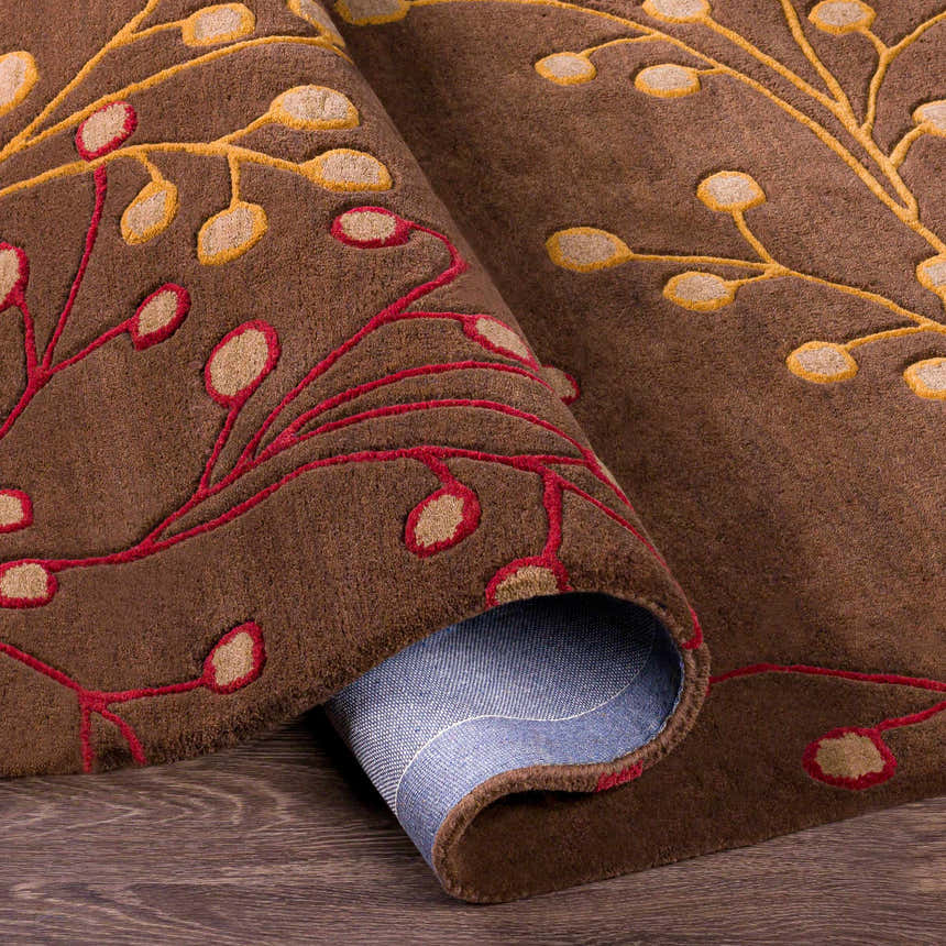 Close-up of the Brown Elsu Area Rug, a hand-tufted wool rug with a floral design in brown, burgundy, and gold. Fold